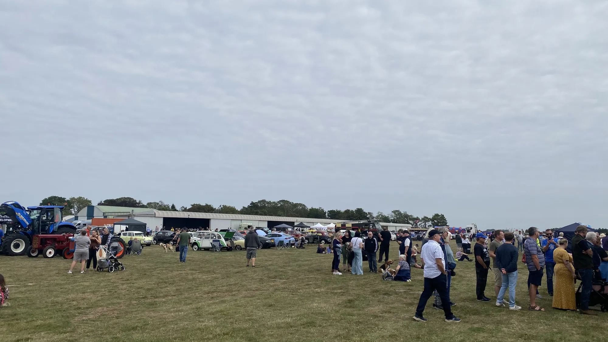 Crowds enjoying Wings and Wheels with classic cars and aircraft on display
